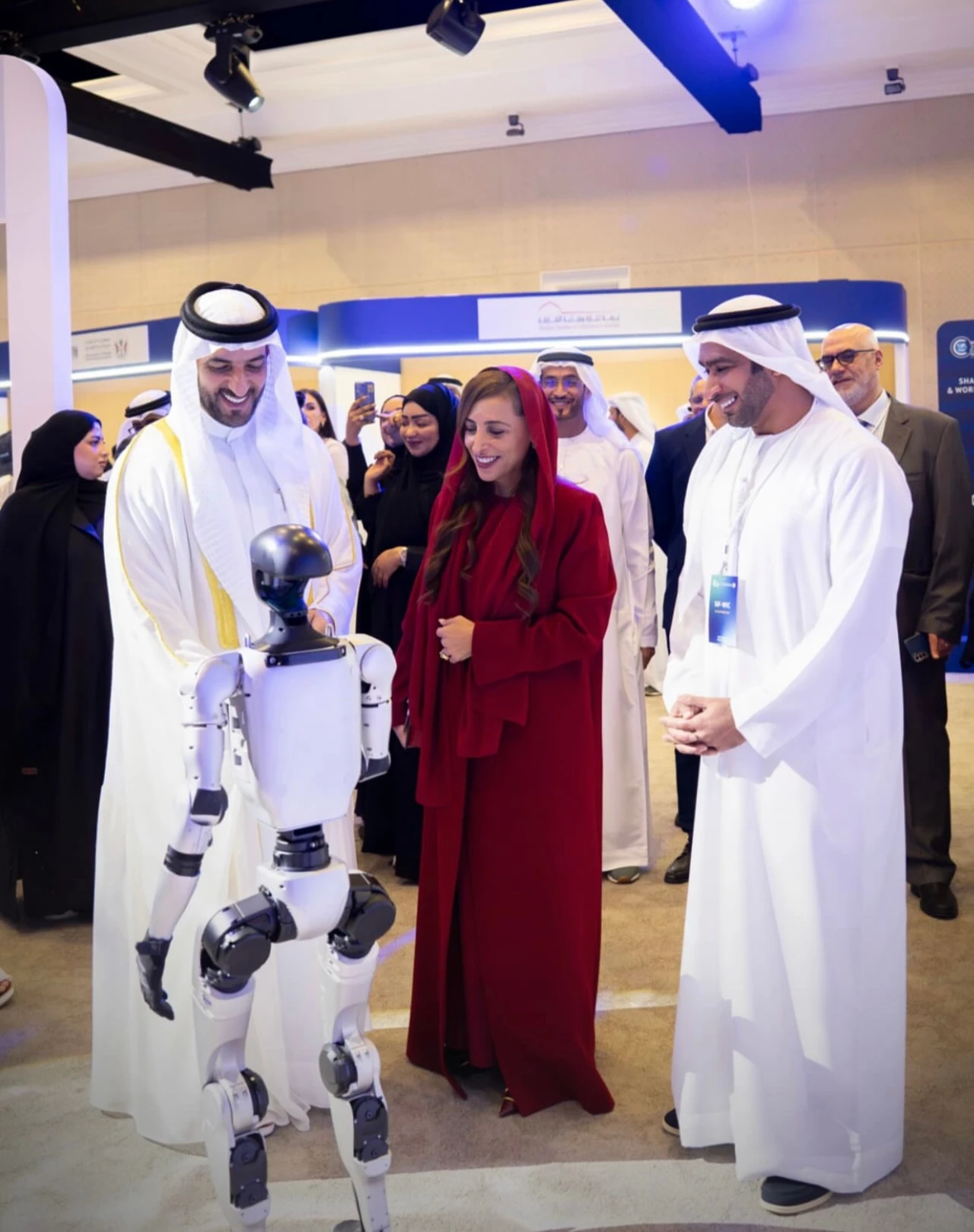 Visitors smiling beside a humanoid robot at an indoor event