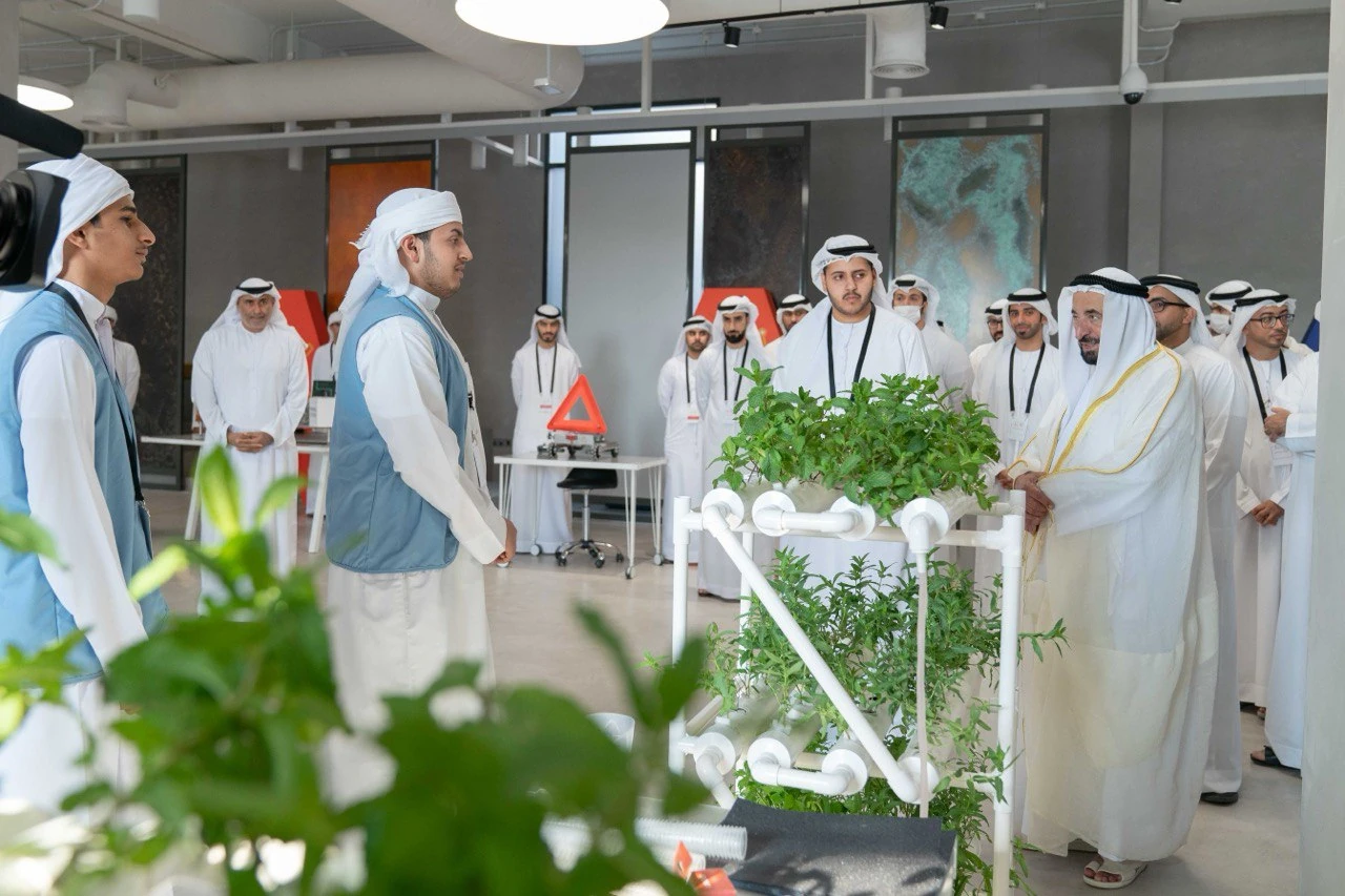 People discussing a planted pipe assembly during a laboratory visit