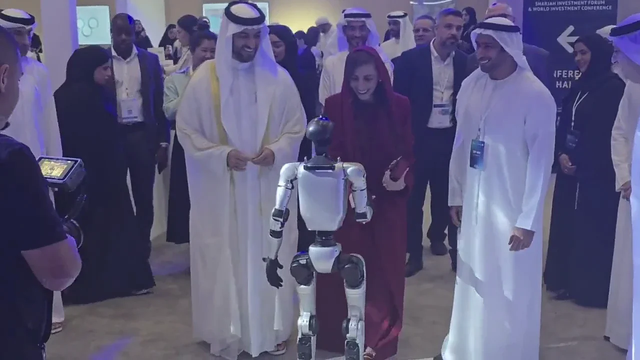 Visitors smiling as they interact with a humanoid robot at an indoor event