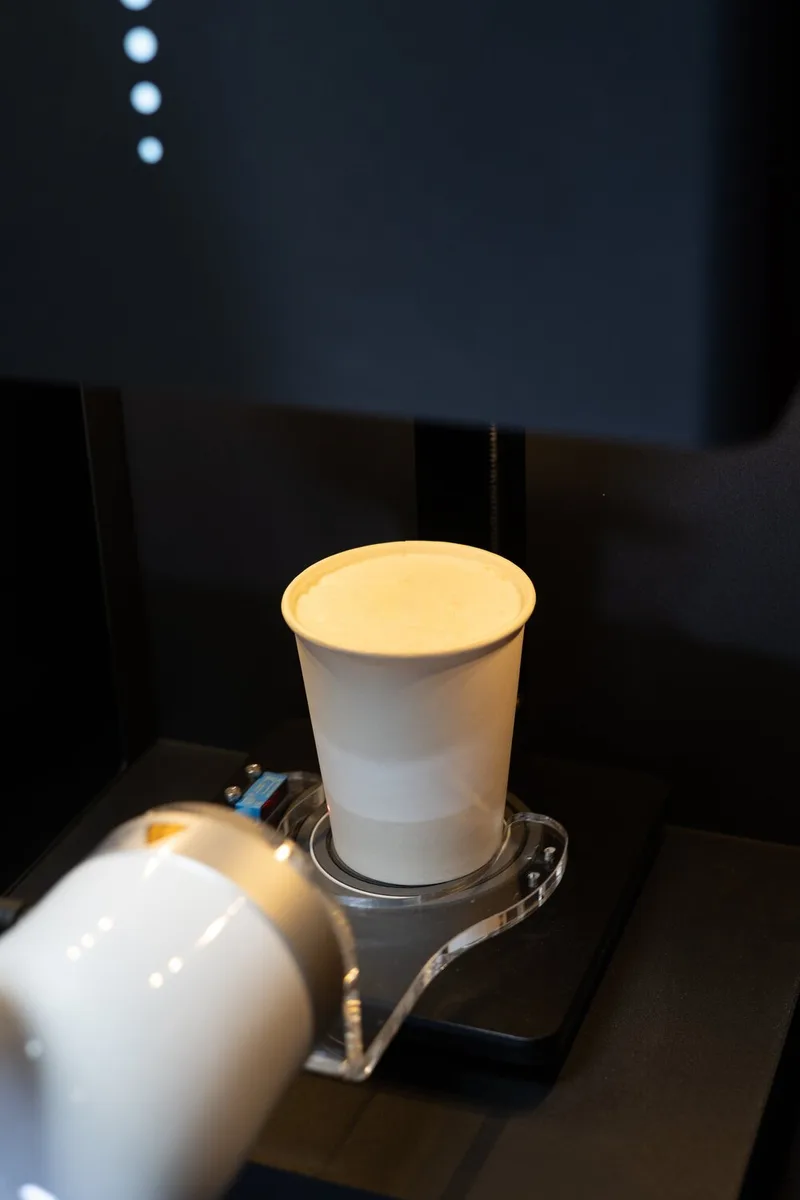 Robot arm beside a freshly made coffee in the robotic barista